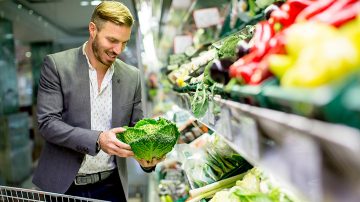 man picking fresh vegetables at store