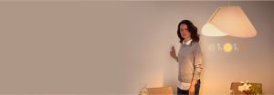 "Mujer ajustando el regulador de intensidad inteligente, que controla el ambiente de iluminación LED cálida en un espacio de vida contemporáneo con decoración minimalista"