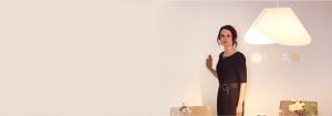 "Mujer que ajusta la iluminación LED empotrada brillante mediante un elegante regulador montado en la pared, mejorando el ambiente y la eficiencia energética de la sala de estar moderna".