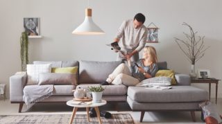 Dos personas sentadas en el sofá de casa disfrutando de la luz LED de alta calidad