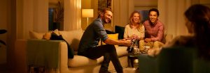 "La cálida iluminación LED crea un ambiente acogedor para los amigos que socializan en el salón, destacando la iluminación de bajo consumo para las reuniones nocturnas".