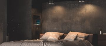 Una cama cómoda iluminada por puntos de luz cálidos