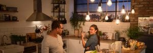 "Cocina moderna con luminarias colgantes LED de estilo vintage que iluminan a dos mujeres que disfrutan de la cena, creando un ambiente cálido y acogedor".