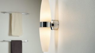 "Baño moderno con una elegante lámpara de pared LED, que ilumina la decoración minimalista y realza el ambiente de spa".
