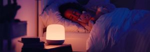 "Luz nocturna LED inteligente que emite un resplandor suave y cálido mientras el niño duerme plácidamente, mostrando una iluminación personalizable a la hora de acostarse para un entorno de sueño óptimo".
